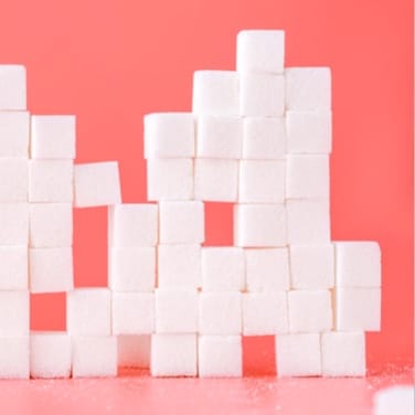 a stack of sugar cubes on a pink background